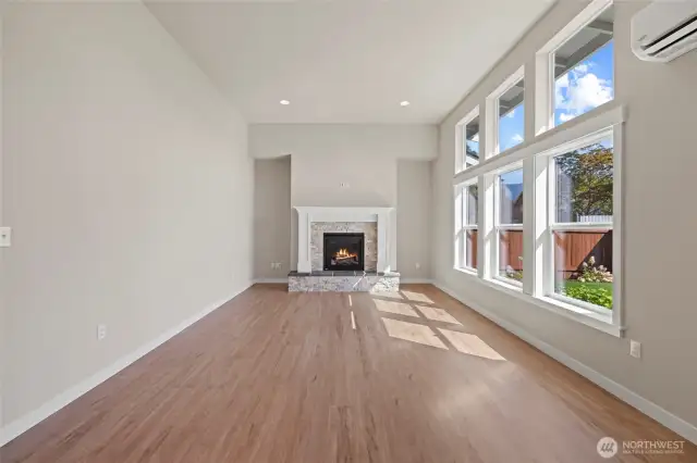 The great room is tall and a wall full of glass.