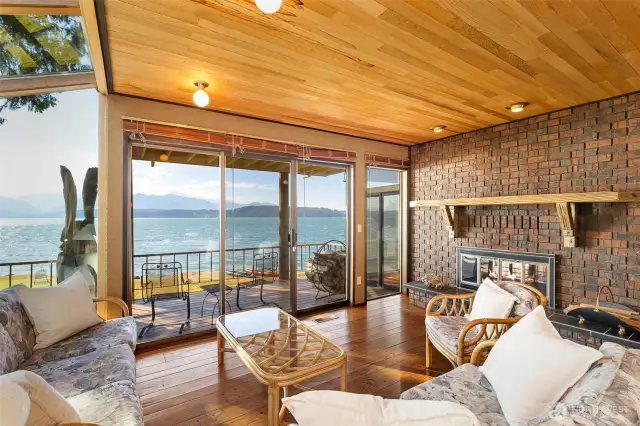 Another view of the family room together with a fireplace and insert.  The sculpture you see outside on the deck is your very own resident eagle!  Carved on site from a tree that the deck was built around!