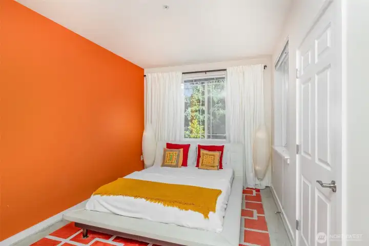 Light-filled corner of the primary suite with closet conveniently positioned to the right.