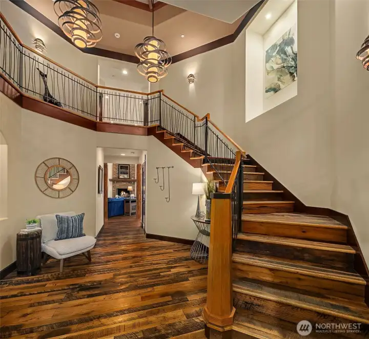 Grand staircase in entry rotunda.  Hand scraped wood floors throughout the main level and upper hallways