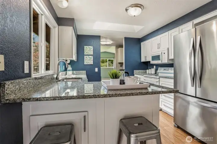 Light, bright kitchen with skylight, breakfast bar, slab granite counters.