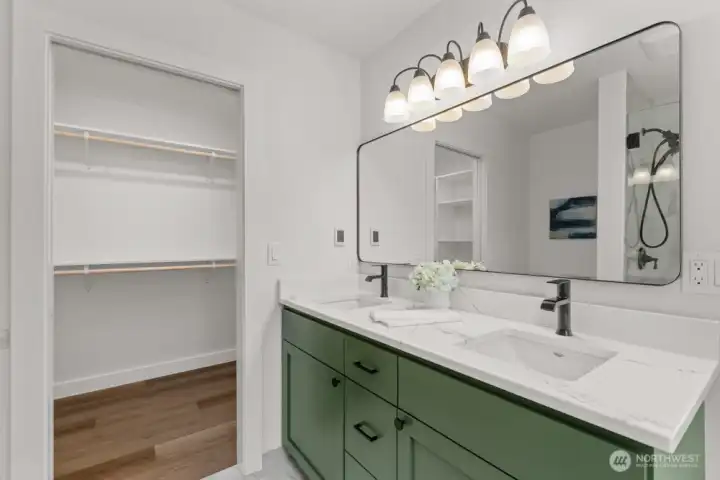 With quartz counters, a dual vanity and a generous walk-in closet, this space balances style and function with ease.