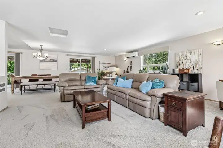 Open-concept living room, with dining area behind.