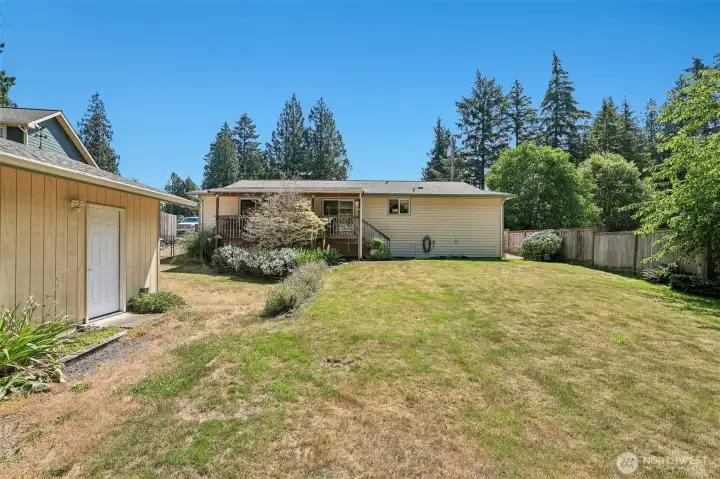 Rear exterior of the house with the large detached garage on the left.