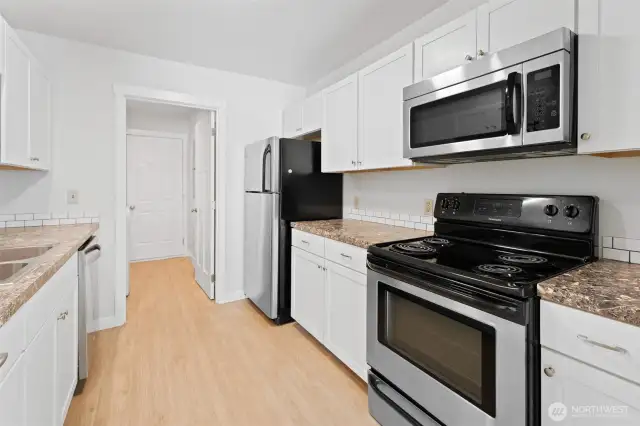 galley kitchen leads to laundry room and door to back yard