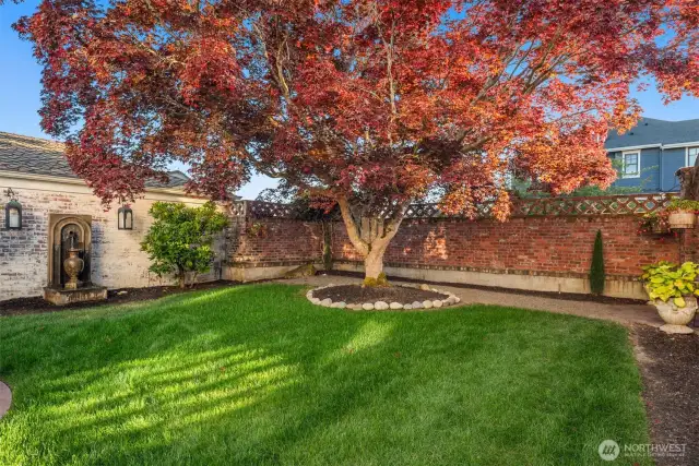 Step into the inviting backyard with old-world charm of a Tuscan villa, where dappled sunlight filters through mature maple trees. Ivy covered brick walls add privacy, making the patio with, BBQ grill,  the custom brick fireplace and pizza oven the perfect setting for sharing fine wine and memorable meals.