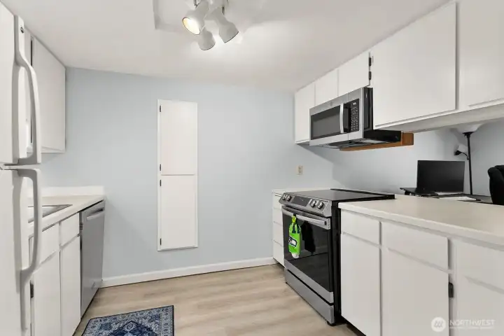 Kitchen opens to living room and overlooks dining room and windows.