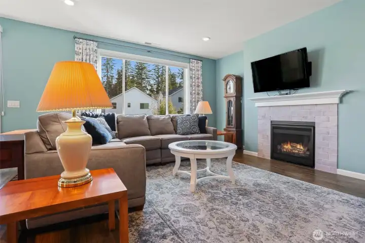 Main floor great room with a formal living room featuring a gas fireplace opens to the kitchen and dining room with sliding door to the back deck with Cascade Mountain views and southern exposure.