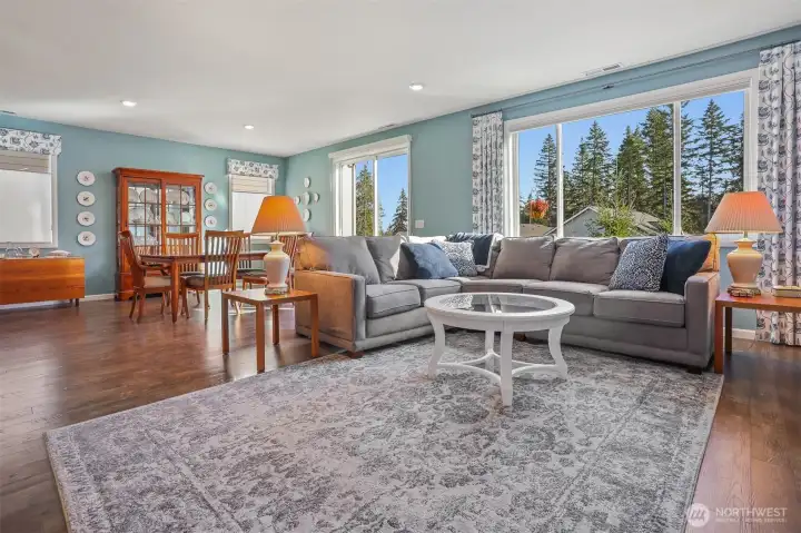Main floor great room with a formal living room featuring a gas fireplace opens to the kitchen and dining room with sliding door to the back deck with Cascade Mountain views and southern exposure.