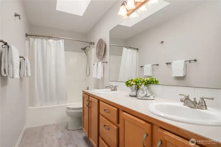 The main bathroom features new LVP flooring, a skylight and dual sinks as well as fantastic storage.