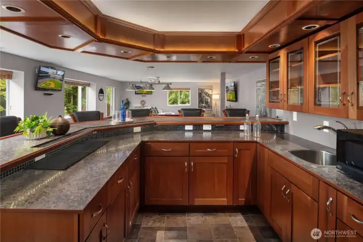 Custom cabinetry with granite counters and tiled floors as well as glass upper cabinets.