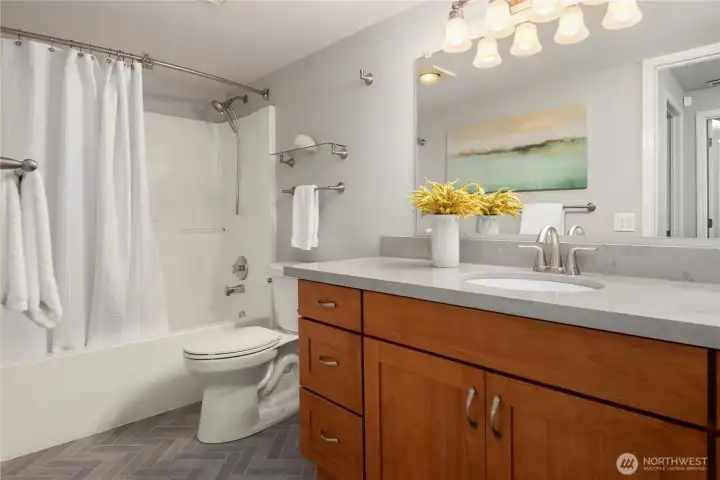 The lower bathroom features an oversized vanity and tiled floors.