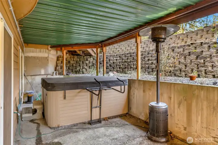 Covered Hot tub sits outside the lower level