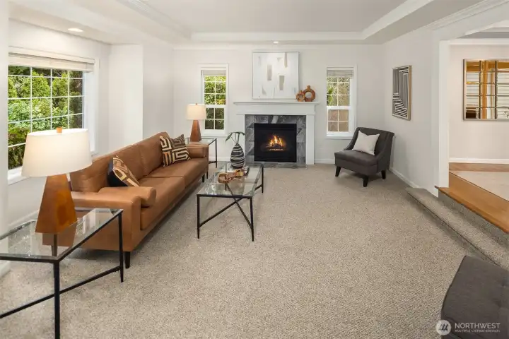 The front step down living room has new carpet & fresh paint, gas fireplace, and flows into the dining room  to the right