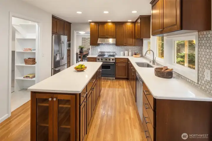 This spacious kitchen has plenty of cabinet space for storage, and a larger walk in pantry closet. Tiled back splash and Quartz Counters. Double wall ovens & Microwave Oven to the left next to the Refrigerator.