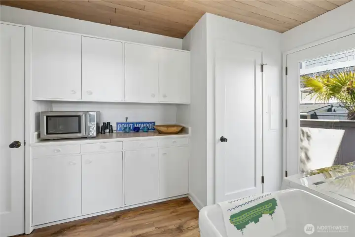 Laurdry room has lots of storage cabinets .