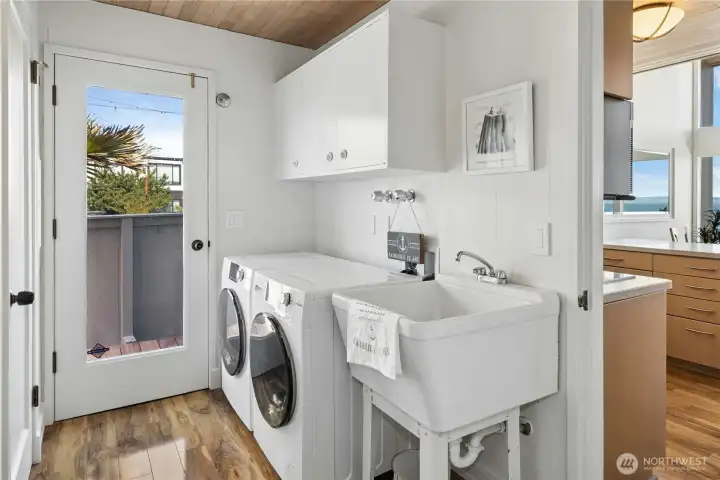 Newer washer and dryer and vintage utility sink complete laundry room.