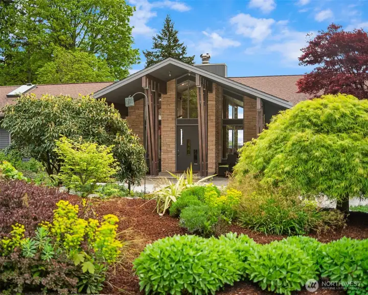 Striking architectural entry framed by curated gardens sets the tone for this extraordinary residence.