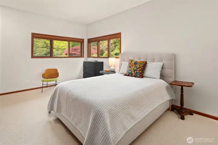 Spacious second main-level ensuite bedroom with private bath and tranquil garden views.