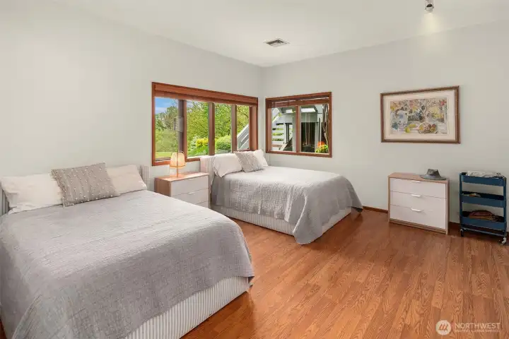 Generously sized third bedroom with warm natural light and easy access to lower-level living spaces.