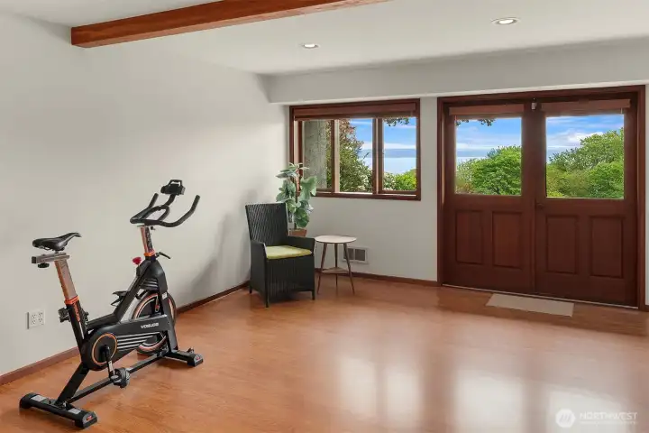 Light-filled bonus room with French doors opening to the front porch—an ideal setting for fitness, media, or studio use, with easy access to a half bath.