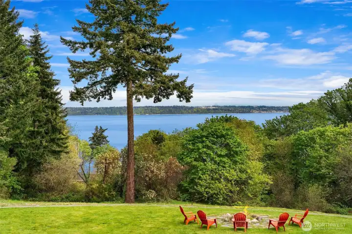 Gather around the firepit on the sweeping lawn, where open skies and water views create a magical setting.