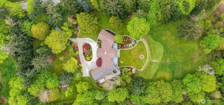 A loser aerial view captures the scale and serenity of the estate’s park-like grounds—an extraordinary setting of curated gardens, open meadow-like lawns and privacy.