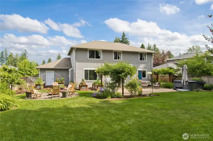 The fully fenced backyard offers a large patio, established fruit trees, garden space, a fire pit gathering area, and a hot tub that conveys with the property The fully fenced backyard offers a large patio, established fruit trees, garden space, a fire pit gathering area, and a hot tub that conveys with the property