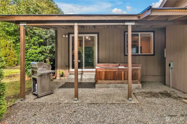 Covered patio with very clean hot tub.