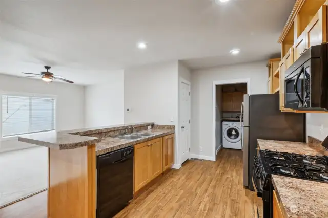 Kitchen with a new gas stove. Pantry closet and laundry room at the back. Washer and dryer stay!