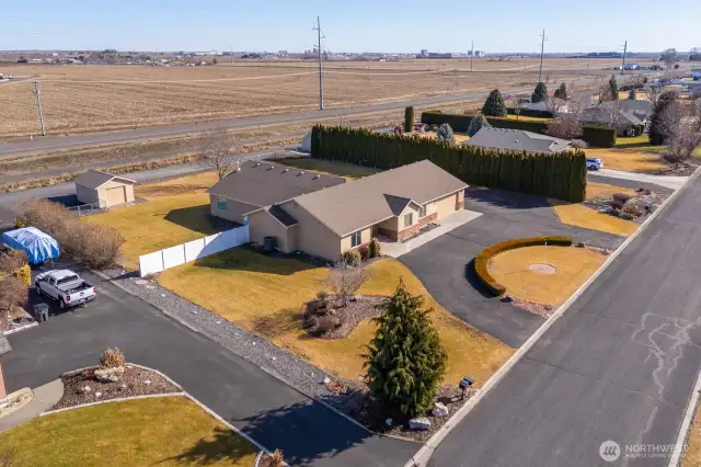A broadly sweeping ariel view of the elegant front and fenced backyard. Note the extra parking area beside the shop. The shop is equipped with electricity and a workbench.