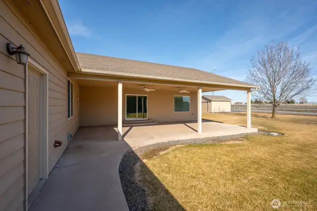 A view of the door to the garage on the left, the patio and entry into the great room, and the shed.