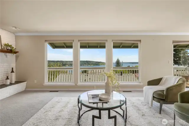 More of the main floor living room with view windows and a fireplace to the left of the picture