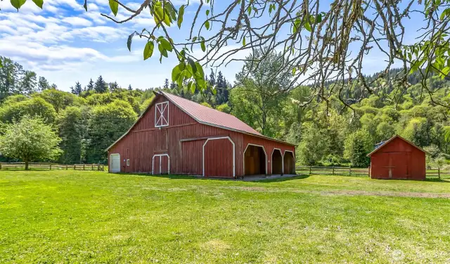 This outbuilding is approx 48' x 70' with all concrete flooring.  The white roll-up door at left opens to a full-length aisle/bay.  At right are three open, over height bays - could easily fit a car lift or two.  At far right is the garden tool shed.