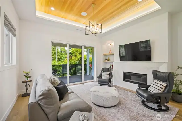 Look up and let the warmth surround you—tray ceilings with natural wood inlay and ambient lighting add architectural depth and a touch of modern luxury to this inviting living space. It’s a design detail that quietly elevates every moment, from cozy mornings to evening gatherings.