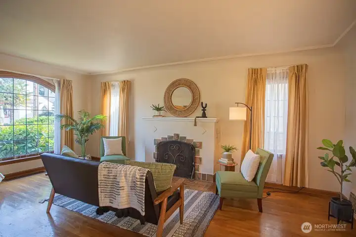 Spacious living room with tons of natural light and original fireplace and screen