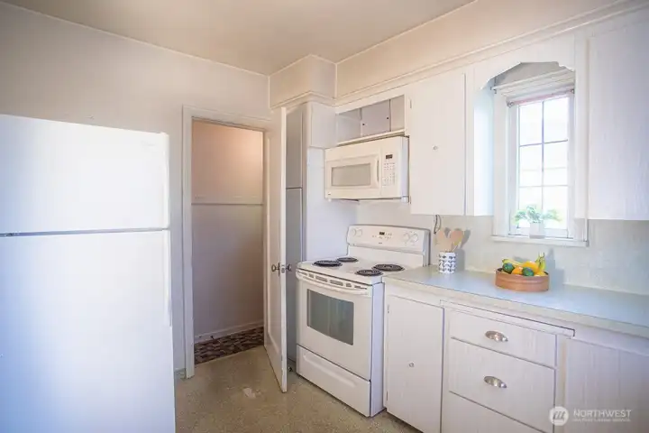 Kitchen with doorway to the side entry into the house and the stairs to the lower level