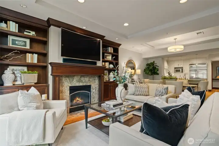Open living room with gas fireplace and custom built-ins.