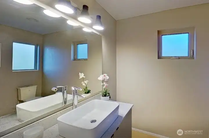 The 1/2 bath features a handsome quatrz vanity with plenty of under cabinet storage.