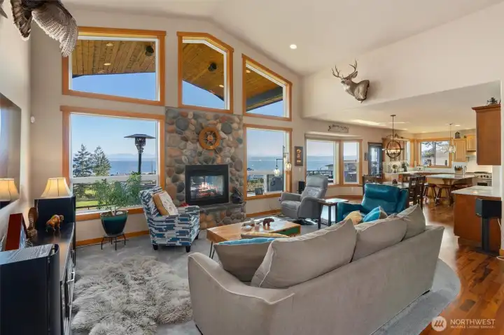 Living room with dual-sided gas fireplace opens to dining and kitchen