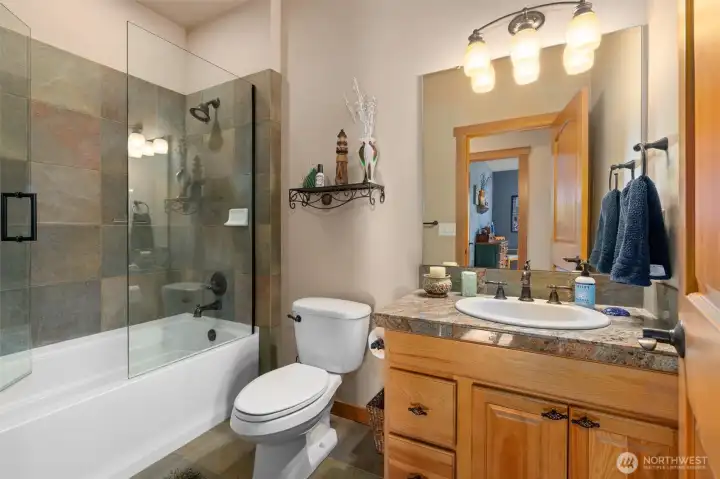 Full guest bath with granite counters and tile floors
