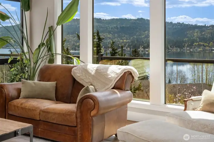 Living room with vaulted ceilings, window wall & gas fireplace. New hardwood floors, doors & trim on the main level & Milgard Windows throughout.
