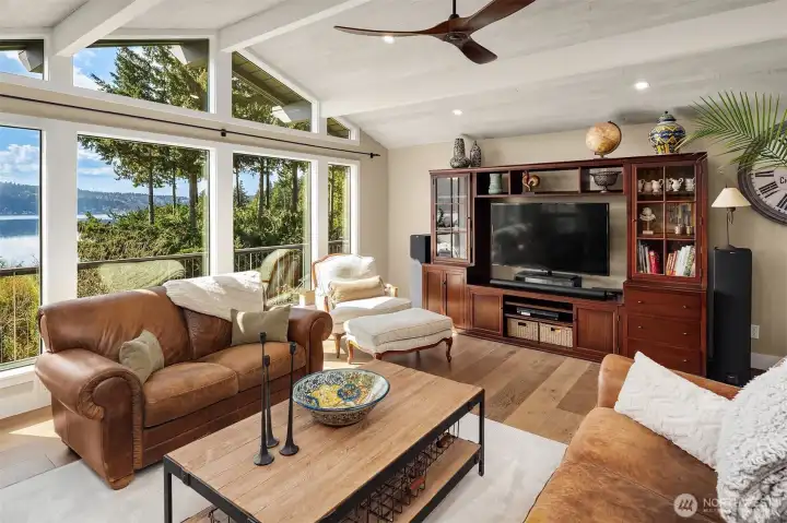 Living room with vaulted ceilings, window wall & gas fireplace. New hardwood floors, doors & trim on the main level & Milgard Windows throughout.