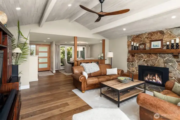 Living room with vaulted ceilings, window wall & gas fireplace. New hardwood floors, doors & trim on the main level & Milgard Windows throughout.