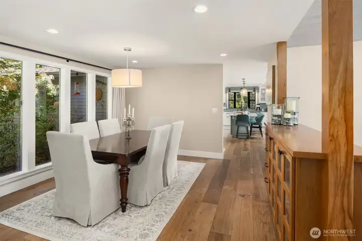 Living room with vaulted ceilings, window wall & gas fireplace. New hardwood floors, doors & trim on the main level & Milgard Windows throughout.