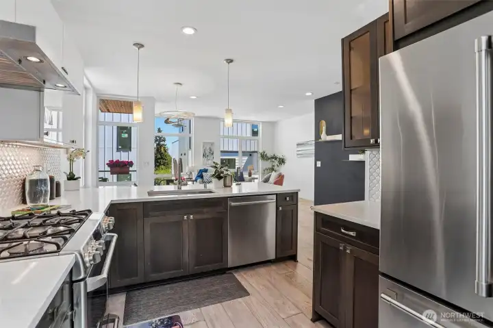 Gourmet kitchen with powerful range hood over five burner cooktop, and ultra-quiet Bosch dishwasher.