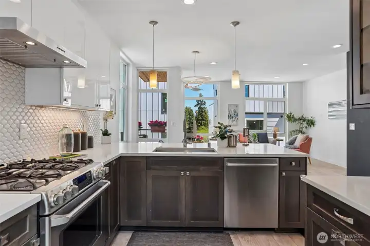 Gourmet kitchen with powerful range hood over five burner cooktop, and ultra-quiet Bosch dishwasher.