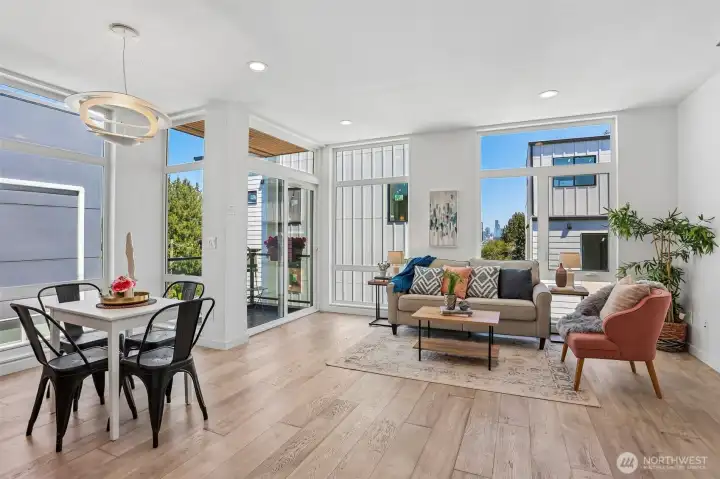 Floor-to-ceiling windows in the air conditioned living room and dining room lavish the space in light. To the left is the deck with convenient access from the kitchen. To the right is the view of Downtown and the Great Wheel.