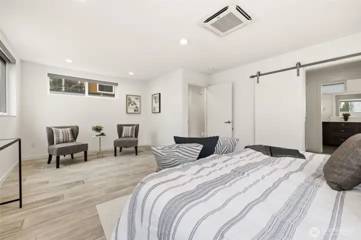 Oversized and air conditioned primary suite with sitting area, spacious custom closet, and heated tile floors in the primary bath.