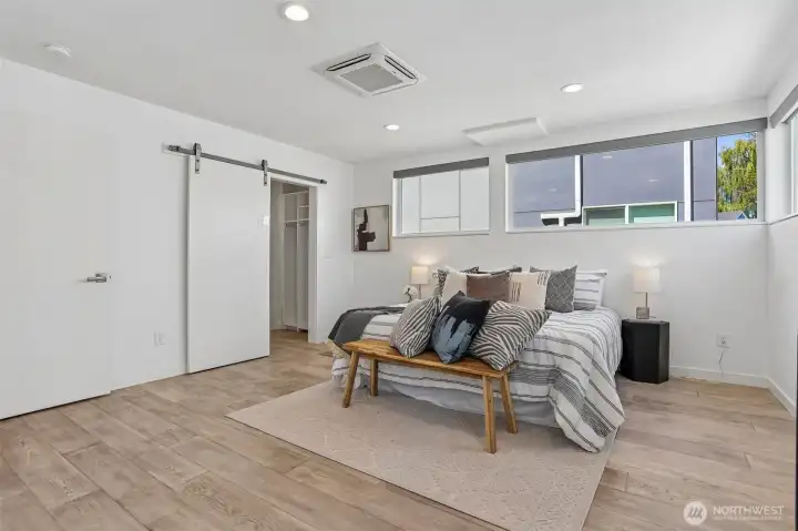 Oversized and air conditioned primary suite with sitting area, spacious custom closet, and heated tile floors in the primary bath.
